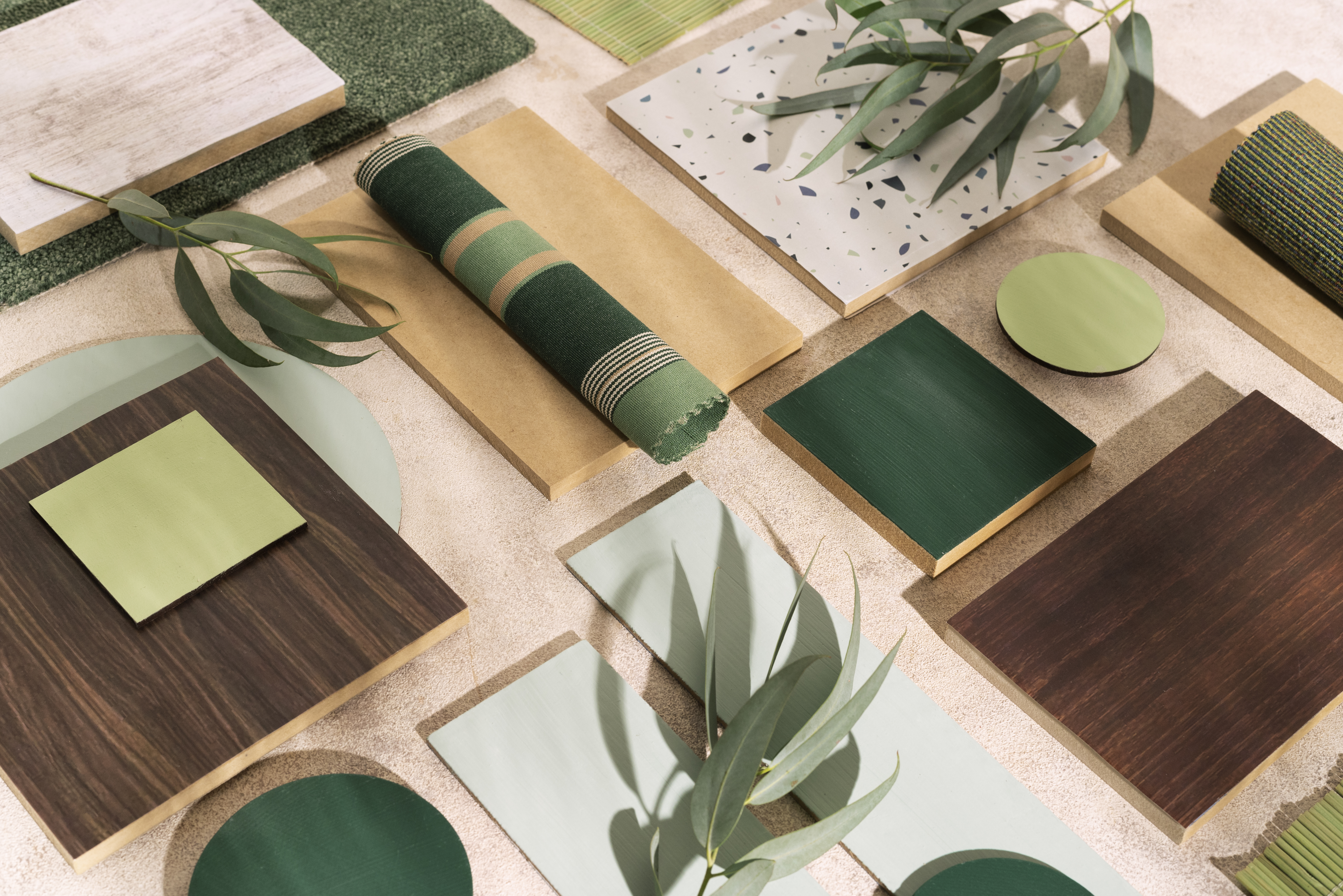 Top view of interior design workspace with MDF boards, fabric samples, and design materials